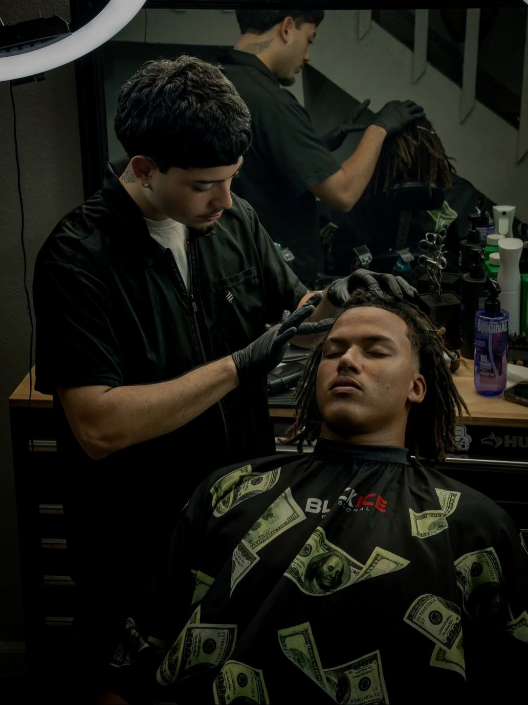 Diego Sandoval finishing a cut in the shop, client in the chair